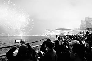 Crowd viewing the Lunar New Year Fireworks Display at the Central harbourfront with the Convention and Exhibition Centre and other buildings in Wanchai in the distance, 20 February 2015