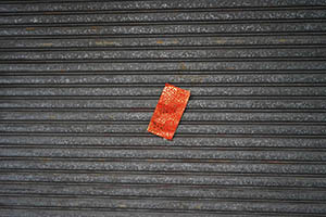 Red paper on the shutters of a closed shop, Tai Kok Tsui, 21 February 2015