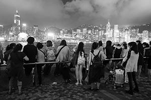 People on the waterfront at night, with a view of Victoria Harbour and Hong Kong Island, Tsim Sha Tsui, 15 May 2015