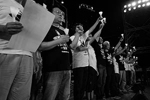 People on the stage holding up candles during the June 4th memorial rally, Victoria Park, 4 June 2015