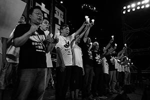 People on the stage holding up candles during the June 4th memorial rally, Victoria Park, 4 June 2015