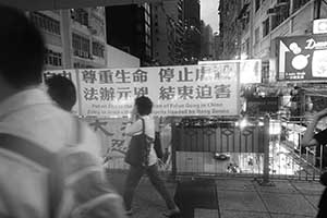 Banner protesting against the alleged persecution of Falun Gong, on an overhead walkway, Wanchai, 1 September 2015