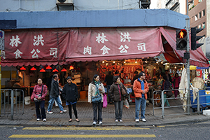 People crossing the road in front of a butcher's shop, Ma Tau Kok Road, To Kwa Wan, 19 December 2015
