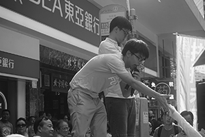 Joshua Wong (front) addressing demonstrators at the annual protest march, Yee Wo Street, Causeway Bay, 1 July 2016