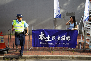 Policeman and banner of localist group 'Hong Kong Indigenous', during the annual pro-democracy march from Victoria Park, Hennessy Road, Wanchai, 1 July 2017