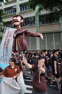 Woman holding a puppet in a march from Causeway Bay to Admiralty against the extradition bill, Wanchai, 16 June 2019