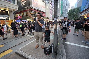 A boy and his father take turns to address crowds on a march from Causeway Bay to Admiralty against the extradition bill, Johnston Road, Wanchai, 16 June 2019