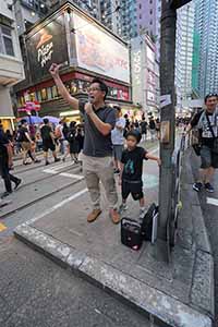 A boy and his father take turns to address crowds on a march from Causeway Bay to Admiralty against the extradition bill, Johnston Road, Wanchai, 16 June 2019
