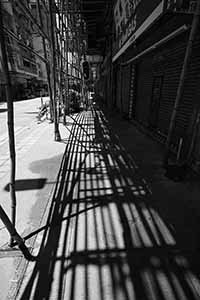 Shadows of scaffolding on the street, Kowloon, 2 June 2019