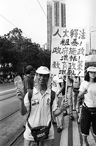 Man with a protest sign on the  pro-democracy march from Victoria Park to Central, 1 July 2004