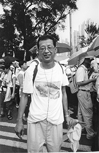 Man in a white T-shirt with a crocodile photo on it, on the pro-democracy march from Victoria Park to Central, 1 July 2004