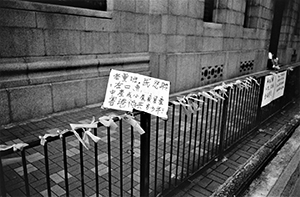 Protest sign left on a railing during the pro-democracy march from Victoria Park to Central, 1 July 2004