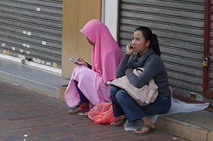 Two women sitting outside closed shops, Sham Shui Po, 3 February 2014