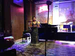 Pianist Sophia Yan making an announcement prior to playing music composed by Joyce Tang in response to a photograph by David Clarke, Fringe Club, Central, 18 November 2016