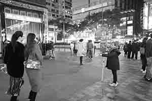 A woman holding an advertising board and giving out flyers, Peking Road, Tsim Sha Tsui, 28 February 2017