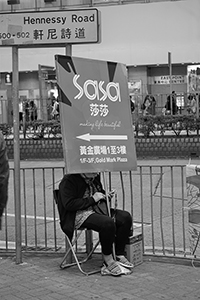 A person with a Sasa advertisement sign on the street, Hennessy Road, Causeway Bay, 6 February 2017