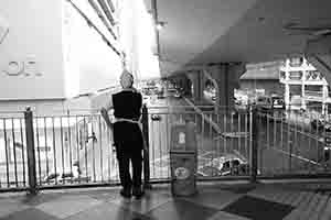 Smoker near a rubbish bin, on a footbridge over Connaught Road Central, Sheung Wan, 25 March 2017