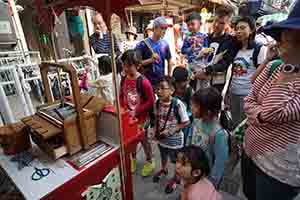 Children watching artist To Wun making traditional craft objects for sale, Cheung Chau, 4 April 2017