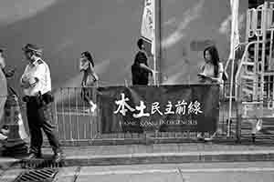 Policeman and banner of localist group 'Hong Kong Indigenous', during the annual pro-democracy march from Victoria Park, Hennessy Road, Wanchai, 1 July 2017