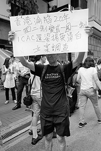 Man with a sign, annual pro-democracy march from Victoria Park, Great George Street, Causeway Bay, 1 July 2017