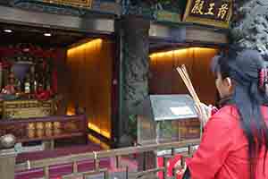 Woman wishing for luck at Wong Tai Sin temple, Kowloon, 30 January 2018