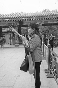 Woman wishing for luck at Wong Tai Sin temple, Kowloon, 30 January 2018