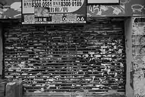 Shuttered shop space with property advert and remnants of posters, Mongkok, 24 June 2018