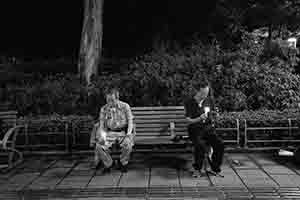 Two men on a bench, during the annual memorial rally in Victoria Park, Causeway Bay, 4 June 2018