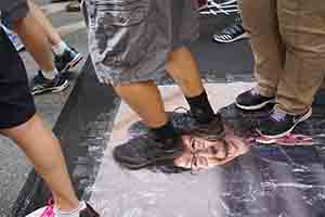 Stepping on a portrait of Carrie Lam during the annual pro-democracy march, Hennessy Road, Wanchai, 1 July 2018