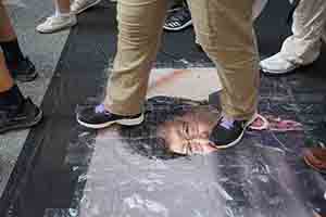 Stepping on a portrait of Carrie Lam during the annual pro-democracy march, Hennessy Road, Wanchai, 1 July 2018