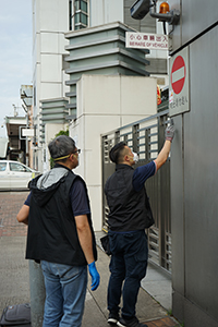 Police dusting for fingerprints at the entrance of the Liaison Office of the Central People's Government, after vandalism in a protest on the previous day, Sai Ying Pun, 22 July 2019