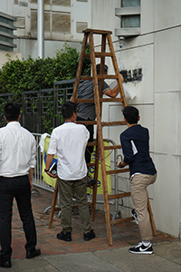 Police investigating the entrance of the Liaison Office of the Central People's Government, after vandalism in a protest, Sai Ying Pun, 22 July 2019