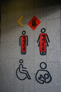 Posters on a toilet sign, Harcourt Road, Admiralty, 5 August 2019