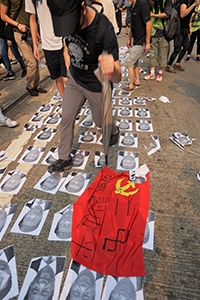 Protester stepping on photos of Xi Jinping and a communist flag, global anti-totalitarianism march, Hennessy Road, Wanchai, 29 September 2019