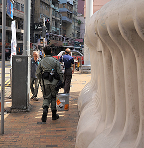 Policeman carrying a bucket containing hazardous goods, Des Voeux Road West, Sai Ying Pun, 7 November 2019
