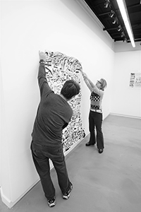 Artist Chak installing an artwork by Kwok Mang Ho in the Visual Arts Centre, Kennedy Road, 11 December 2019