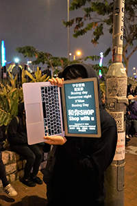 Protestor with a digital sign on a computer screen, rally in support of Spark Alliance, Edinburgh Place, Central, 23 December 2019