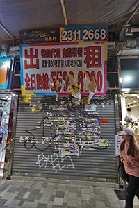 Graffiti and torn posters on a shop for rent, Nathan Road, Tsim Sha Tsui, 26 December 2019