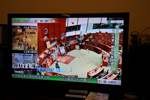Live news on the television in a restaurant in Wanchai showing the police clearance operation at the Legislative Council, 2 July 2019