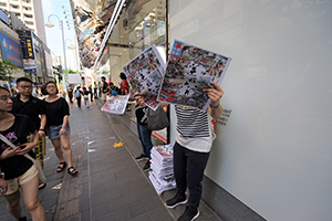 People handing out copies of Apple Daily, 1st July annual protest rally and march, Great George Street, Causeway Bay, 1 July 2019