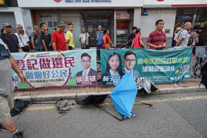 Abandoned umbrellas and banner featuring Lam Cheuk-ting, 'Reclaim Sheung Shui' protest against parallel traders from China,  San Fung Avenue, 13 July 2019