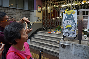 People taking photos of a poster outside the closed Prince Edward MTR Station entrance, 1 September 2019