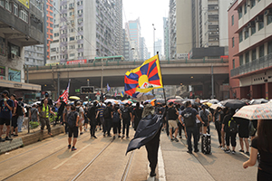 Protester waving the flag of Tibet, global anti-totalitarianism march, Hennessy Road, Causeway Bay, 29 September 2019