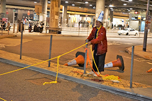 Man clearing a roadblock at Tamar Street, Admiralty, 1 January 2020