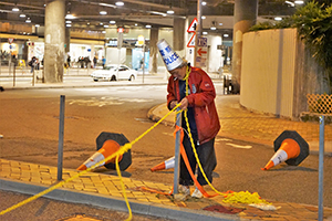 Man clearing a roadblock at Tamar Street, Admiralty, 1 January 2020