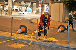 Man clearing a roadblock at Tamar Street, Admiralty, 1 January 2020