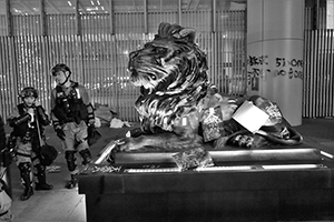 Police examine damage to a vandalized lion sculpture outside the Hong Kong Bank Building, Central, 1 January 2020