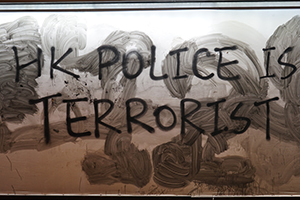 Graffiti on top of partially-erased graffiti, at a tram stop on Des Voeux Road Central, Central, 1 January 2020