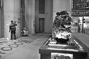 Vandalized lion in front of the Hong Kong Bank Building, and worker cleaning graffiti, Des Voeux Road Central, Central, 1 January 2020