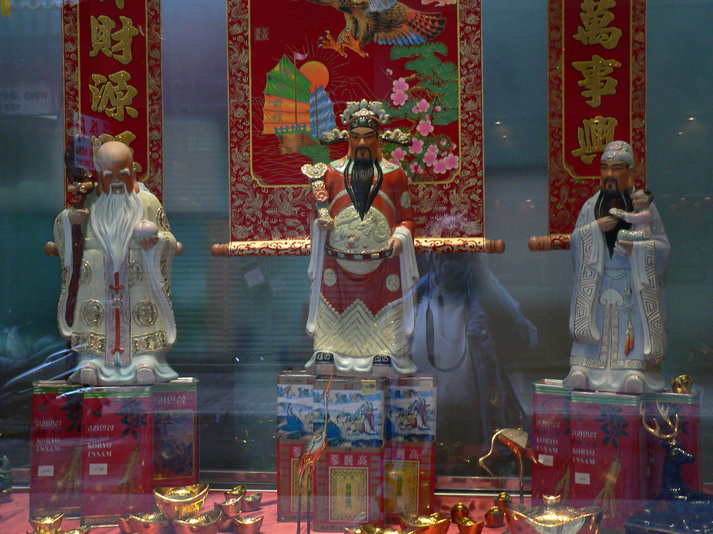 Traditional Chinese god figurines placed in a shop window, Sheung Wan